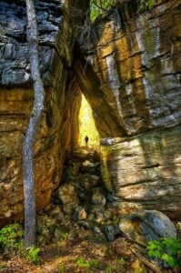 Towering sandstone formations create narrow passages and bouldering routes at Needleseye Park in Oak Hill, one of southern West Virginia's fastest-growing outdoor recreation destinations near the New River Gorge.