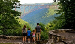 A family enjoys a quiet moment overlooking the New River Gorge Bridge. Many first-time visitors underestimate the size of the national park region and end up wishing they had planned a longer stay, local tourism officials say. (Photo: David Sibray)
