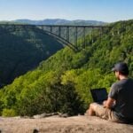 Fayetteville businessman Sean Clarke works remotely above the New River Gorge, a region whose appeal is growing appeal not only as a recreation destination but also as a place to live, work, and build new businesses.