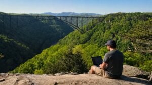 Fayetteville businessman Sean Clarke works remotely above the New River Gorge, a region whose appeal is growing appeal not only as a recreation destination but also as a place to live, work, and build new businesses.