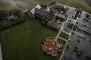 An aerial view reveals the distinctive cruciform design of the Our Lady of Fatima Garden at St. James Church in Charles Town. Created to commemorate the centennial of the Fatima apparitions in Portugal, the prayer garden is featured in Peggy Stanton's The United "Saints" of America as one of West Virginia's unexpected Catholic treasures.