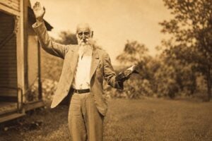 Rev. Dyke Garrett, the mountain preacher who rode horseback through the rugged hills of southwestern West Virginia for more than 50 years, ministers to a gathering of Appalachian families. Garrett became one of the few trusted figures among both the Hatfield and McCoy families during the infamous feud.