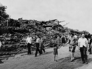 Residents walk past a massive pile of debris after the devastating Shinnston tornado of June 23, 1944. The storm killed 103 people and remains the deadliest tornado in West Virginia history, destroying homes and businesses across Harrison County and neighboring communities.