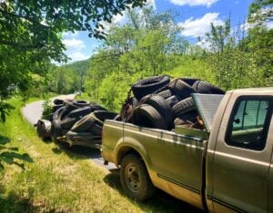 A truck and trailer loaded with discarded tires leave Winona following the community cleanup, one of several loads removed during an effort that collected nearly 7.7 tons of trash from the Fayette County community.