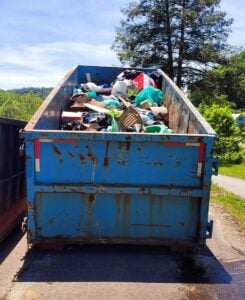 A large collection bin overflows with trash gathered by volunteers during the Winona community cleanup. Household waste, discarded furniture, and other debris were collected as residents worked together to remove nearly 7.7 tons of litter from the Fayette County community.