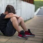 A child sits alone while coping with the loss of a loved one. About one in seven West Virginia children will experience the death of a parent or sibling before age 18, highlighting the need for grief support programs such as Camp Erin West Virginia. (Photo: Getty Images)