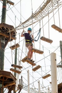 A visitor navigates one of the aerial ropes courses at Heritage Farm Museum and Village near Huntington, West Virginia. The Adventure Park complements the attraction's museums and historic village by encouraging families to experience Appalachia's forests through zip lines, climbing challenges and canopy adventures.