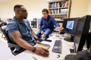 Anthony Sicilia, assistant professor in the WVU Benjamin M. Statler College of Engineering and Mineral Resources, and student Voke Brume study why AI systems believe human users when they should know better, and how to build an AI model that can admit when it’s not sure. (WVU Photo/Brian Persinger)