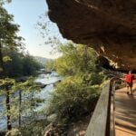 A hiker follows the boardwalk beneath the Alum Cave rock overhang along the Middle Fork River at Audra State Park. The photograph won the outdoor recreation category. (Photo by Stasha Ray)