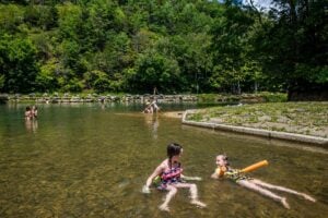 Waders cool off in the clear waters at Blue Bend, a popular swimming hole in the Monongahela National Forest in Greenbrier County, West Virginia. (Photo courtesy Greenbrier Valley CVB)