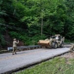 West Virginia National Guard members navigate a partially destroyed road near Buckhannon following severe flash flooding in July 2026. More than seven inches of rain fell in parts of Upshur County, including 4.5 inches in just 37 minutes. (U.S. Army National Guard photo by Edwin L. Wriston)