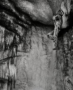 A cave explorer descends by rope into Crookshank Cave in West Virginia in a historic photograph reproduced by historian Charles Carpenter in his writings on the state’s caves.