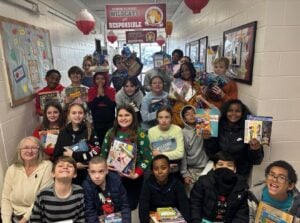 Read Aloud West Virginia Executive Director Dawn Miller, left, joins students at Richmond Elementary School in Kanawha County as they display books provided through the literacy organization’s programs. (Photo courtesy Read Aloud West Virginia)