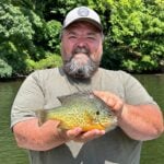 Morgantown angler Robert Glover holds the 9.76-inch pumpkinseed sunfish he caught at Cheat Lake, setting the West Virginia record for a category that has now been broken three times in little more than a month. (Photo courtesy W.Va. DNR)