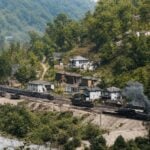 The north end of Thurmond, West Virginia, is shown during the railroad town’s heyday, when homes climbed the steep hillside above the Chesapeake and Ohio Railway and New River. Many of the surviving structures are now part of the Thurmond Historic District. (National Park Service photo, colorized)