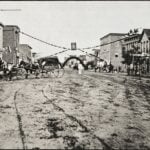 The Bank of Huntington, at right, appears in this view of Third Avenue circa 1880, only a few years after four armed men robbed the bank in 1875. The identities of two of the robbers remain uncertain.