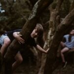 A child climbs a tree while exploring the woods. Outdoor educator Levi Moore says adults can help children develop a lasting connection with nature by giving them opportunities to explore, play and discover outdoors.