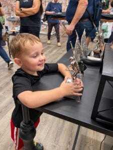A young visitor examines a stainless-steel replica of the famous Mothman statue at The Mothman Statue Legacy in Point Pleasant, West Virginia. (Photo courtesy Mothman Statue)