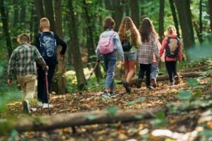 Children explore a woodland trail, where even an ordinary walk can become an opportunity for discovery. Nature educator Levi Moore says adults should allow children time to wander, notice what interests them and develop their own relationship with the outdoors. (Getty Images)