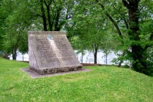 A 1928 monument to Daniel Boone stands near the entrance to Daniel Boone Park in Charleston, West Virginia. The monument commemorates Boone's service in the Kanawha militia and Virginia Assembly and notes that his cabin stood across the Kanawha River.