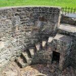 Steps descend inside the stone enclosure of the historic Janutolo Well in Fayetteville, West Virginia. The water source dates to the Civil War era, while the surrounding stonework was added in the early 20th century. (WVExplorer.com photo)
