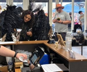 A costumed Mothwoman visits The Mothman Statue Legacy in downtown Point Pleasant, West Virginia, a shop opened by Kelly Roach Miller to celebrate the work of her father, Mothman sculptor Bob Roach. (Photo courtesy Mothman Statue)
