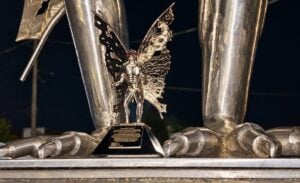 A miniature replica of the Mothman stands at the feet of the original stainless-steel statue created by Bob Roach in Point Pleasant, West Virginia. Roach’s daughter, Kelly Roach Miller, has helped preserve the story behind her father’s famous sculpture.