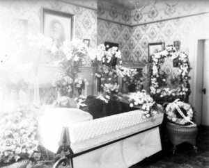 Mrs. G. C. Sturgiss lies in her casket, likely in a Morgantown, West Virginia, home sometime between about 1890 and 1920. Before funeral homes became commonplace, the deceased often remained at home while family and neighbors prepared for burial and gathered to keep vigil. (West Virginia & Regional History Center, WVU Libraries)