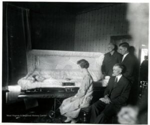 Mourners sit beside the open casket of Mrs. Zarko during her 1927 funeral in Grafton, West Virginia. Keeping company with the deceased and the bereaved was central to traditional funeral customs in many West Virginia communities. (West Virginia & Regional History Center, WVU Libraries)