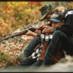 Wesley Scarbrough helps his brother-in-law, Justin, fire a gun while squirrel hunting near Rock Creek, West Virginia, in 1995. The photograph by Lyntha Scott Eiler is part of the Library of Congress Coal River Folklife Project.