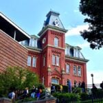 Students walk past historic Woodburn Hall on the West Virginia University campus in Morgantown. WVU has launched a program that allows qualifying high school seniors in Kanawha and Monongalia counties to be admitted without completing a traditional application.