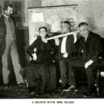 Historic black-and-white photograph of spiritualist medium Elizabeth Winn Blake seated with three men, one holding a long speaking trumpet.