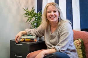 WVU professor Elizabeth Cohen sits beside two copies of Stephen King's The Shining.