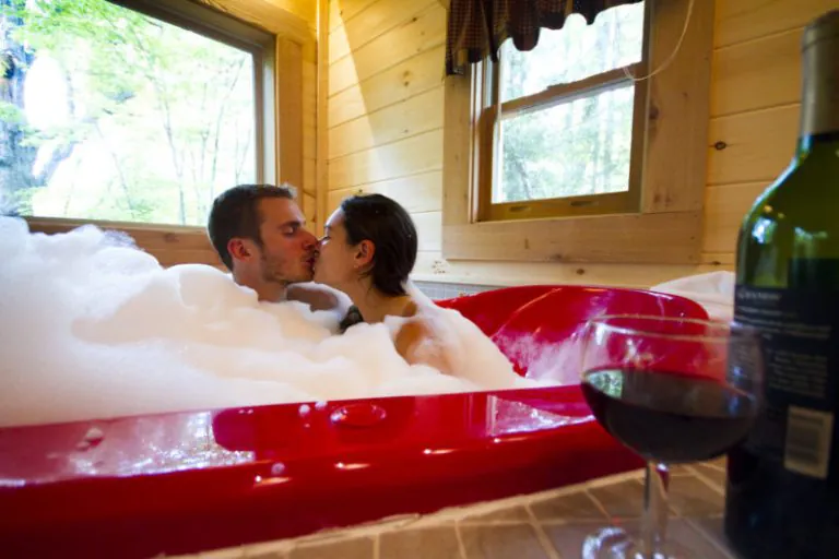 A couple soaks in a heart-shaped tub at County Road Cabins