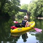 A kayaker leisurely paddles on a West Virginia flatwater trail.