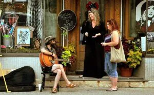 A street musician performs outside a Fayetteville shop.
