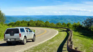 West Virginia Road Trips: A truck travels the Highland Scenic Highway near Marlinton with the Monongahela National Forest stretching across the surrounding mountains. Scenic drives such as this have become a major draw for travelers exploring West Virginia by road. (Photo: David Sibray)
